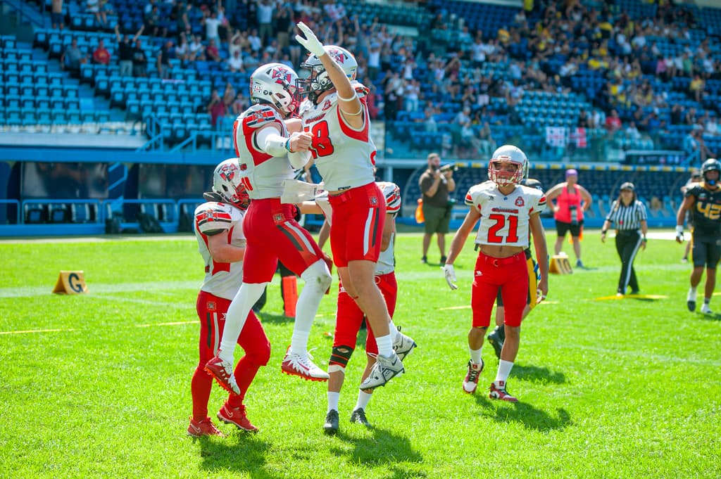 Due giocatori dei Crusaders Cagliari saltano abbracciati per esultare dopo un touchdown