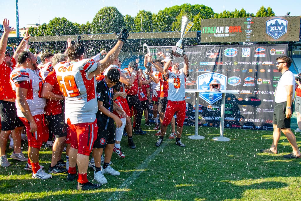 I giocatori dei Crusaders Cagliari alzano il trofeo tra gli spruzzi di spumante sul campo di Ferrara