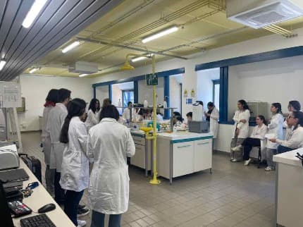 Un gruppo di studentesse in camice bianco all'interno del laboratorio del dipartimento di Scienze biomediche dell'Università di Cagliari a Monserrato