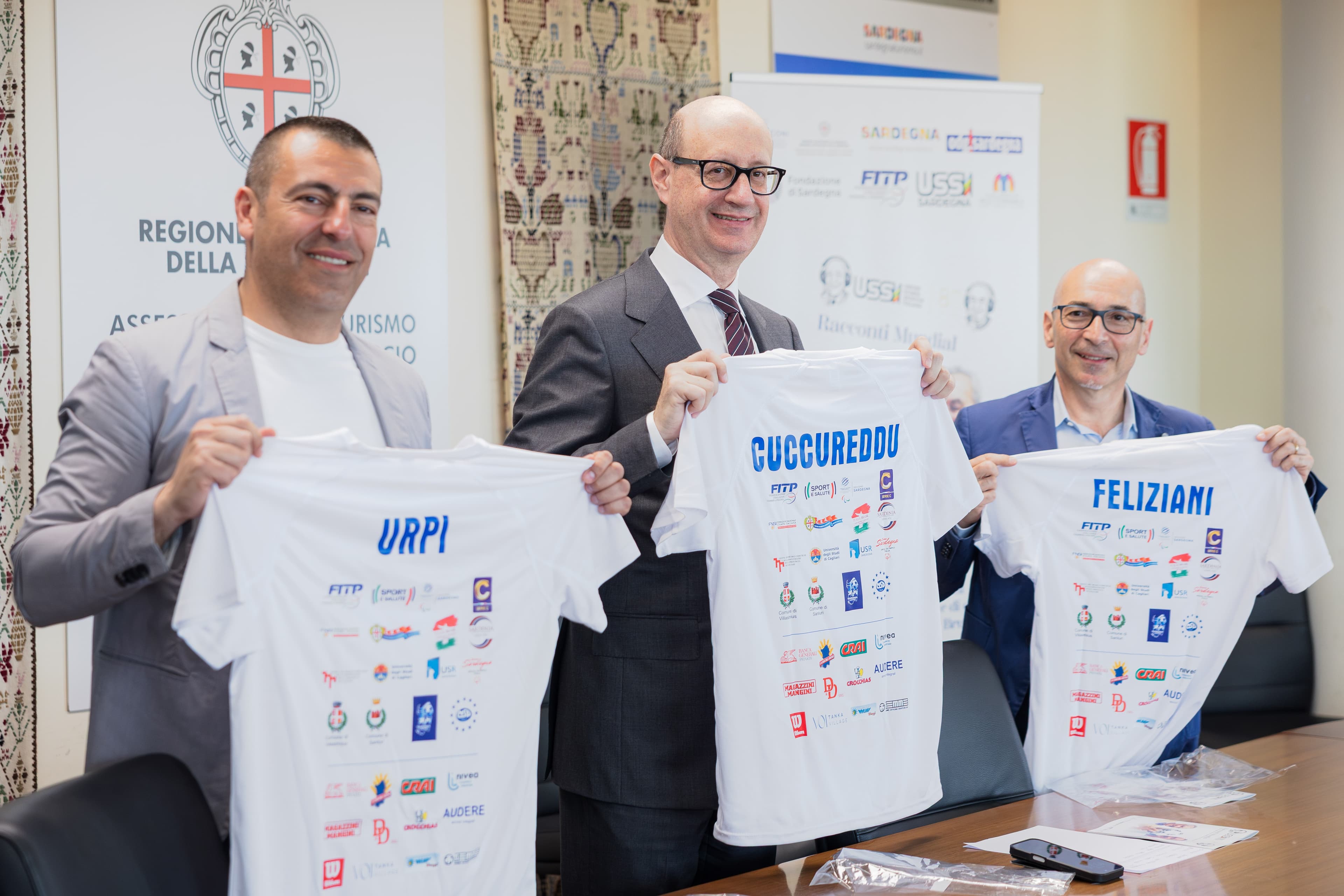 Conferenza stampa Ussi80 a Cagliari: da sinistra Alberto Urpi, Franco Cuccureddu e Francesco Feliziani mostrano le magliette personalizzate dell'evento