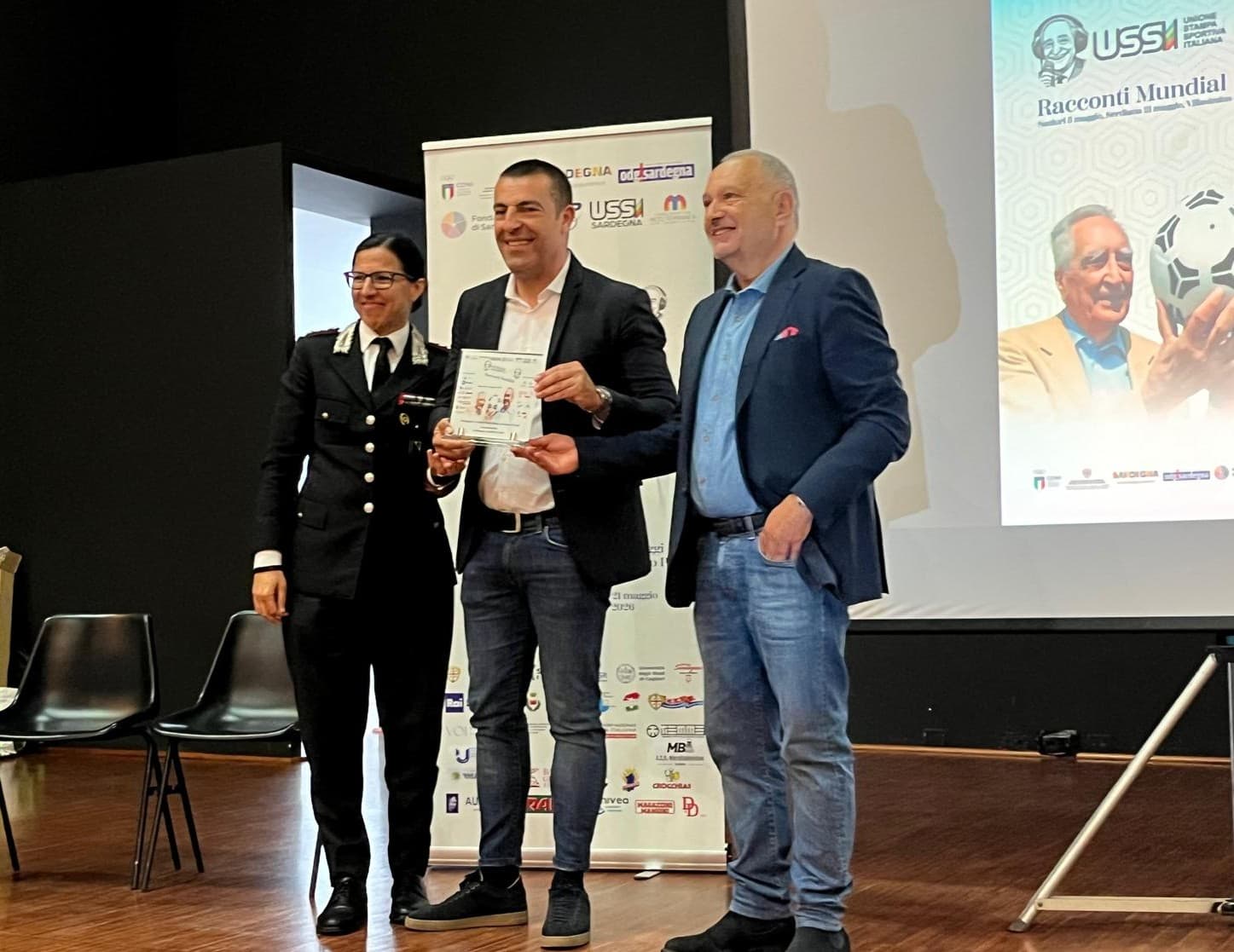 Il sindaco Alberto Urpi con la targa Ussi80 affiancato dalla colonnella Nadia Gioviale e dal magistrato Paolo De Angelis sul palco del Teatro Akinu Congia di Sanluri