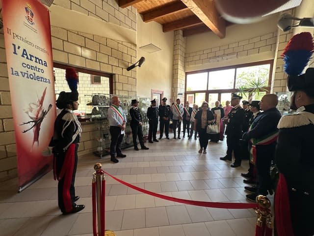 Un carabiniere in grande uniforme accanto al banner della mostra «Il pensiero creativo, l'Arma contro la violenza» al Centro Giovanni Lilliu di Barumini