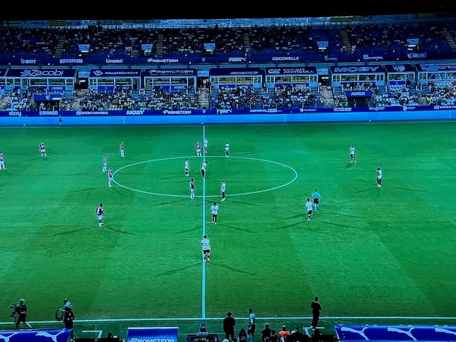 Le due squadre schierate al centro del campo del Tardini poco prima del fischio d'inizio, con le tribune illuminate