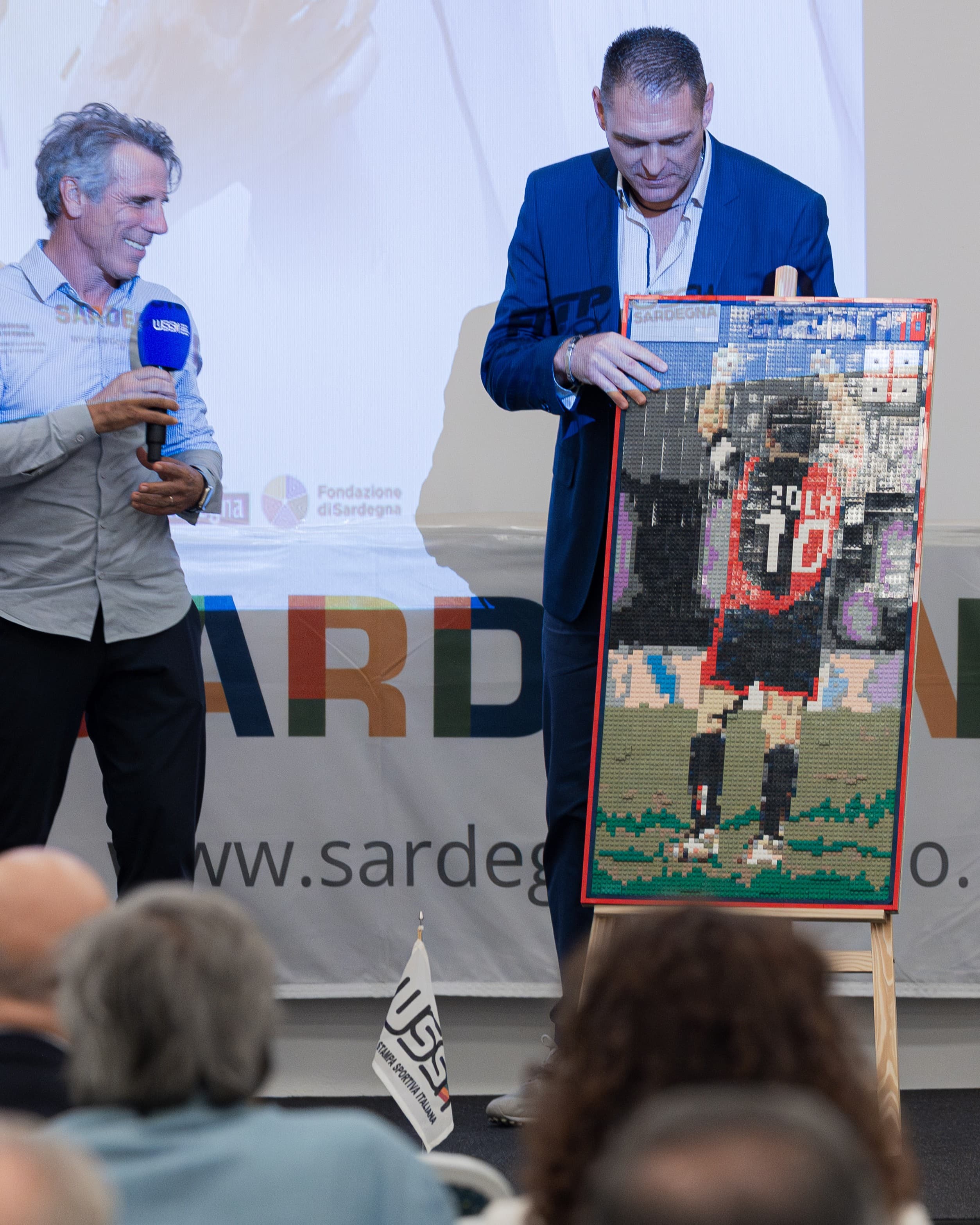 Gianfranco Zola osserva accanto al conduttore il suo ritratto realizzato in mattoncini Lego per gli ottant'anni dell'Ussi